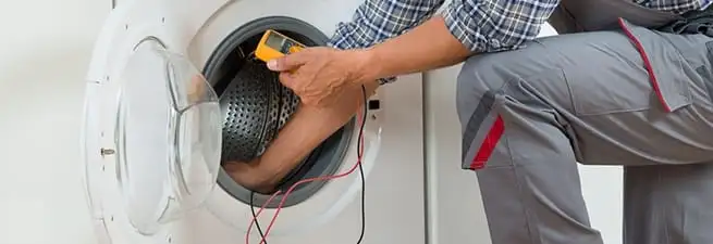 Dryer repair technician inspecting and repairing a clothes dryer in Norfolk, VA