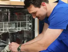 Dishwasher repair technician inspecting and servicing an open dishwasher in Norfolk, VA