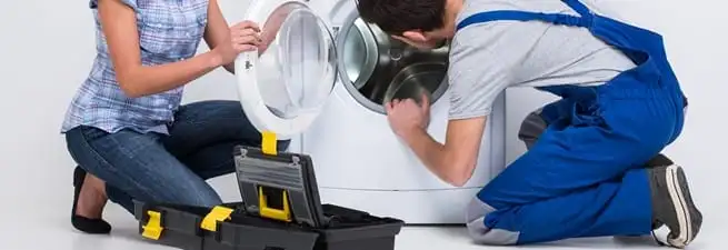 Washer repair technician inspecting a front-load washing machine with tools in Norfolk, VA