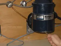 Garbage disposal repair technician tightening the mounting ring under a sink in Norfolk, VA