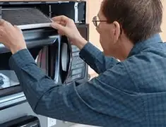 Appliance repair technician replacing a microwave vent filter in Norfolk, VA