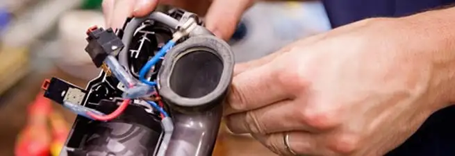 Vacuum repair technician reconnecting wiring and components in Norfolk, VA