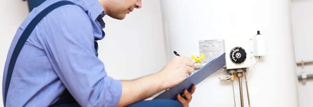 Water heater repair technician inspecting the unit and recording service notes in Norfolk, VA