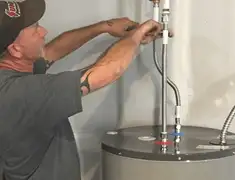 Water heater repair technician tightening supply line connections in Norfolk, VA