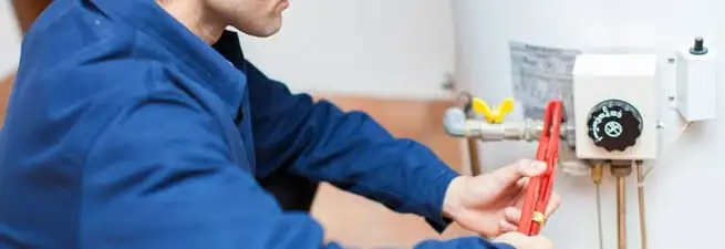 Water heater repair technician adjusting the temperature control and gas valve in Norfolk, VA